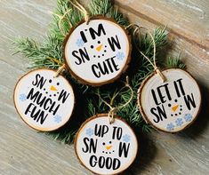 four wood slice ornaments with sayings on them hanging from a pine tree branch in front of a wooden floor