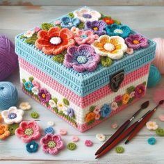 a crocheted box sitting on top of a table next to yarn