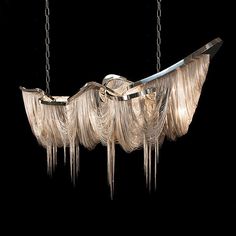 a chandelier hanging from chains in the shape of a boat with feathers on it