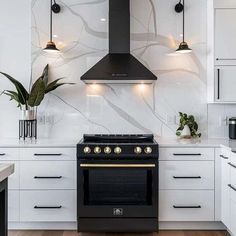 a black stove top oven sitting inside of a kitchen next to white cabinets and counter tops