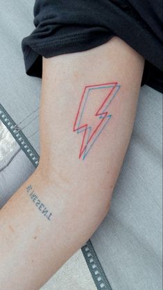 a person with a tattoo on their arm has a lightning bolt in the middle of it