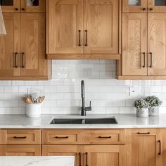 a kitchen with wooden cabinets and white marble counter tops, along with an island in the middle