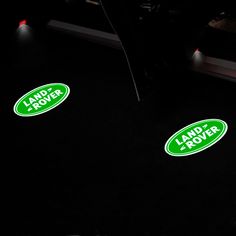 two green land rover stickers sitting on the floor