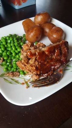 a white plate topped with meat and peas