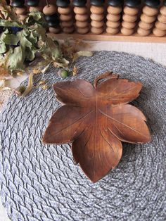 a wooden leaf laying on top of a rug