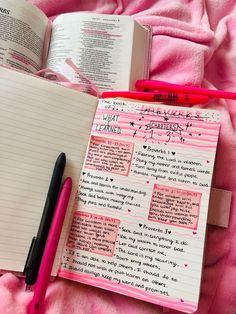 an open notebook with writing on it next to a pink pen and some other items