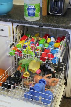 an open dishwasher with toys in it on the bottom shelf, and another item that appears to be fake