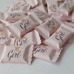 a pile of pink candy wrappers with gold foil stars on them that say it's a girl