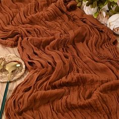 a table topped with a plate covered in brown cloth