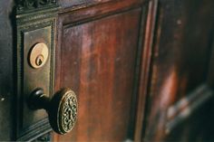 an ornate door handle on a wooden cabinet