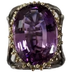 Amethyst oval 21.87cts. with peridot 14 karat yellow gold and silver, containing 22 round peridot weighing .55pts. and 1 large oval amethyst weighing 21.87cts. The ring is made to fit 2 different fingers size 6 and 8.