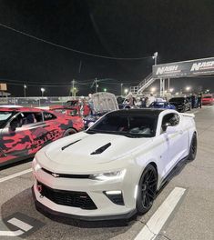 several cars parked in a parking lot at night