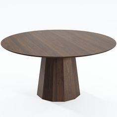 a round wooden table sitting on top of a white floor