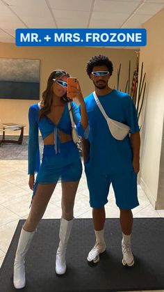 a man and woman in blue outfits taking a selfie