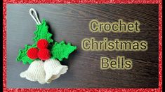 crochet christmas bells with holly leaves and red berries hanging from the top on a wooden background