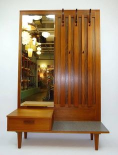 a wooden dresser sitting next to a mirror