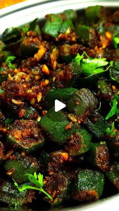 a bowl filled with cooked zucchini and seasoning on top of a wooden table