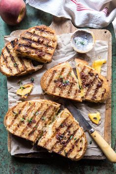 grilled cheese sandwiches with pineapples and herbs on parchment paper next to a knife