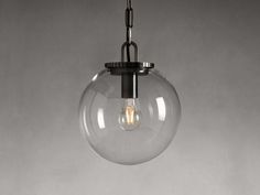 a clear glass globe light hanging from a ceiling fixture