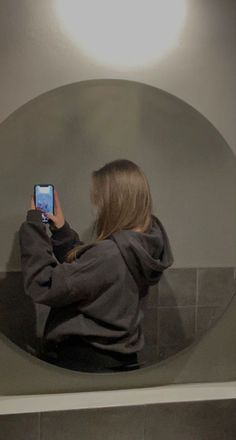 a woman is taking a selfie in front of a mirror with her cell phone