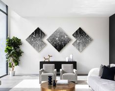 a living room filled with white furniture and paintings on the wall above two couches