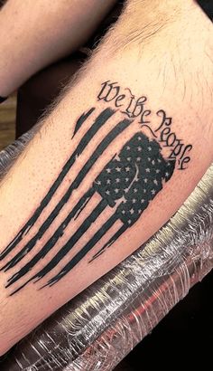 a man's leg with an american flag and we the people written on it