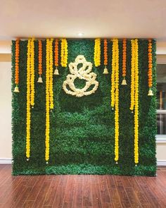 an artificial wall with flowers and candles on it in the middle of a wooden floor