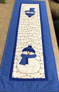 a blue table runner with a snowman on it