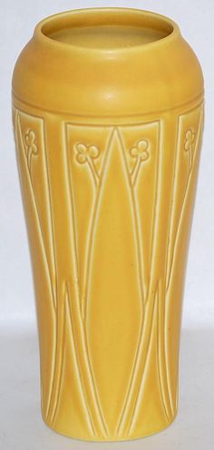 a yellow vase sitting on top of a white table