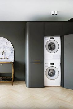 a washer and dryer in a room with grey walls