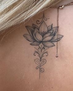 a woman's back with a lotus tattoo on it