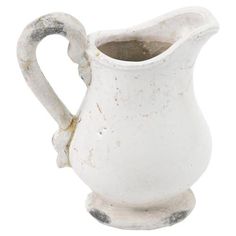 an old white ceramic pitcher is shown on a white background