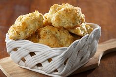 a white basket filled with biscuits on top of a wooden table