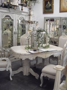 a dining room table and chairs with white paint on the top, surrounded by mirrors