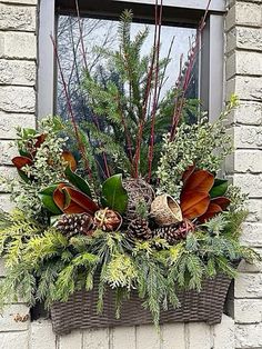 a window box filled with plants and pine cones