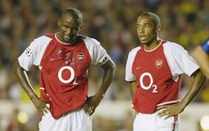 two men standing next to each other on a soccer field