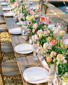 a long table is set up with flowers and candles for an outdoor dinner party or wedding reception