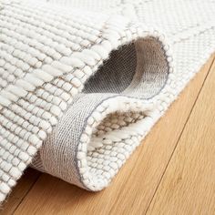 a close up of a rug on the floor with a wooden floor in the background