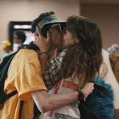 a man and woman kissing each other in an airport