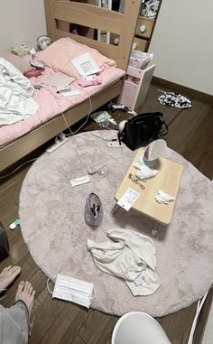 a messy bedroom with clothes and other items on the floor