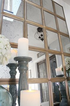 candles are lit in front of an ornate mirror