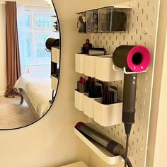 a hair dryer, blowdryer and other items are arranged on the wall