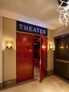 a red door is open to let in light on the theater room's entrance