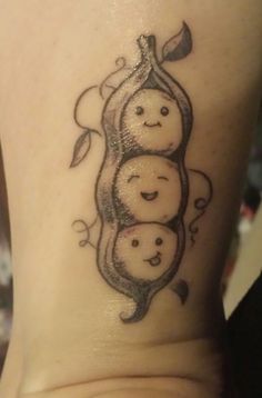 a woman's tattoo with three peas on her stomach