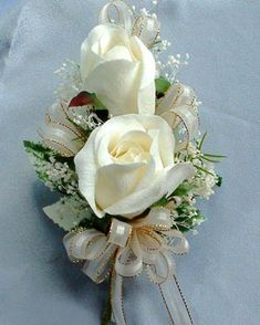 two white roses and baby's breath in a bridal boutonniere