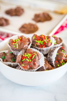 chocolates with sprinkles in a white bowl on a marble counter top