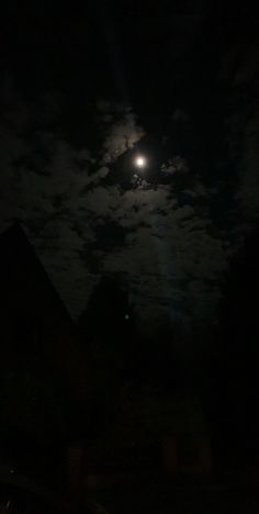 the full moon shines brightly in the dark night sky over some houses and trees