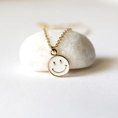 "Beautiful and lovely tiny happy face charm necklace. Made of white enamel gold smiley face charm with skinny gold plated brass chain. Soft and warm. Great for gift , everyday or special occasion. Your item will ship in a gift box. Please feel free to contact me if you have any question. ♥ Length 14\" -20\" chain ♥ Charm 3/8\" ♥ Gold plated over brass / white enamel ♥ Delivery Time Fast shipping within 1 - 3 days ♥ See more Rudiana Accessories Rudiana.etsy.com" Minimalist Hypoallergenic White Charm Necklace, Cute White Nickel Free Necklaces, Cute White Nickel-free Charm Necklaces, Everyday Cute Nickel-free Charm Necklaces, Cute White Nickel-free Necklaces, Cute White Charm Necklaces For Friendship, Cute Gold Friendship Necklace, White Charm Necklace With Delicate Chain For Gift, White Delicate Chain Charm Necklace As A Gift