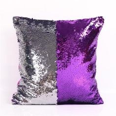 a purple and silver pillow sitting on top of a white floor next to each other