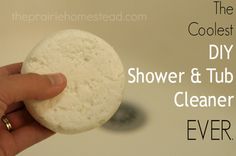 a hand holding a white bath ball with the words, the coolest diy shower and tub cleaner ever